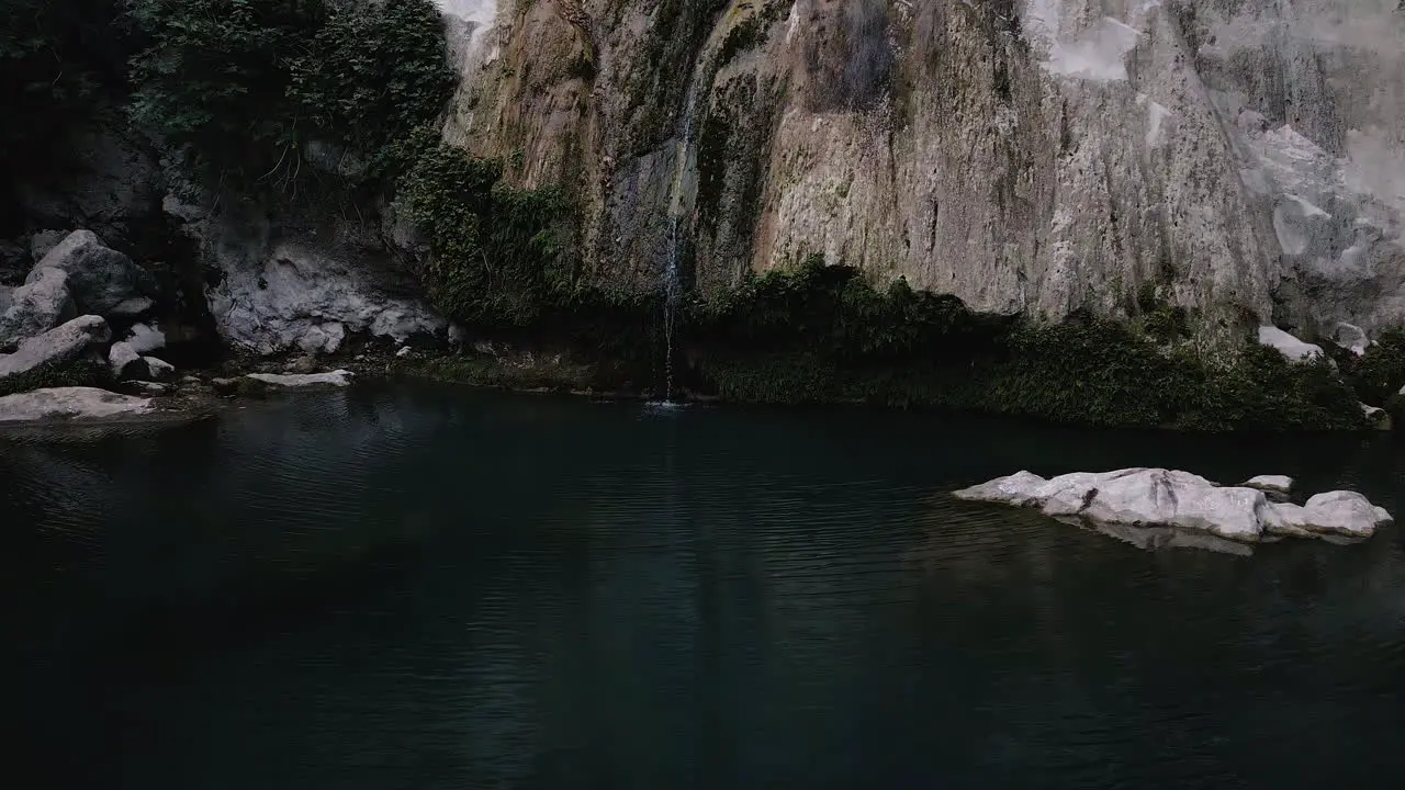 Rock formation with slow running water flowing into pool below