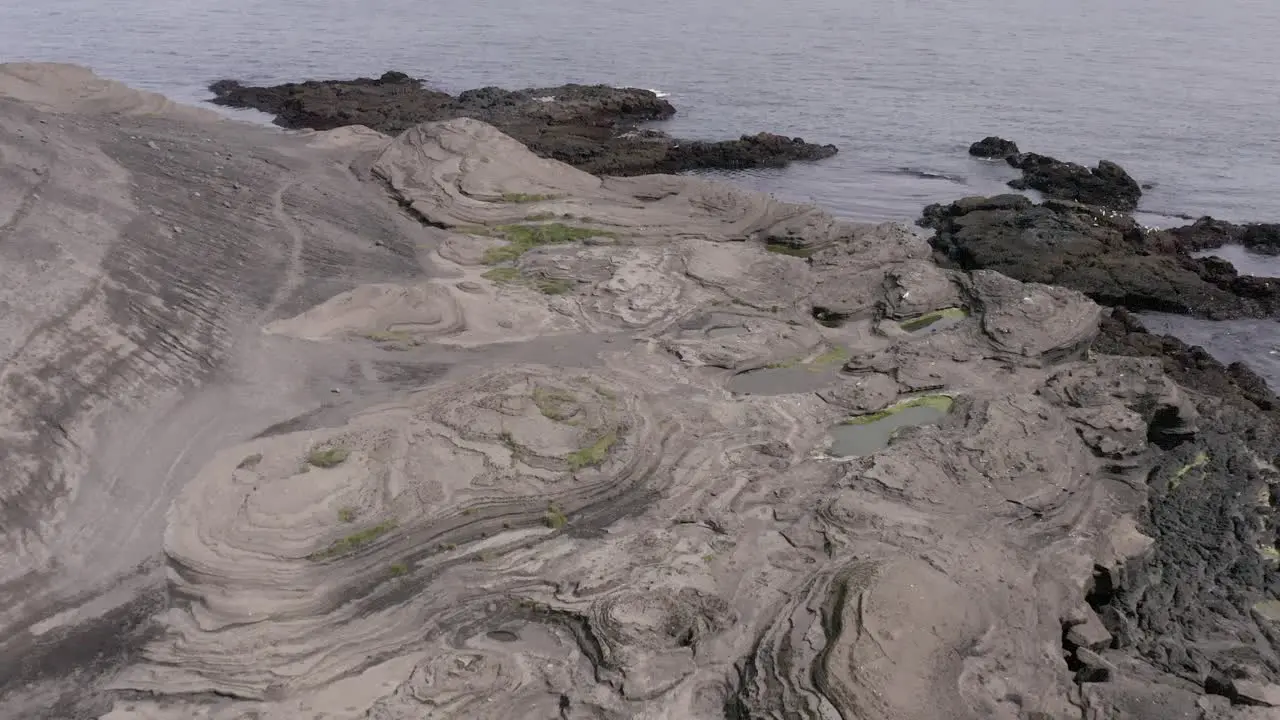 Aerial over rocky beach made of solidified lava on coast of Iceland