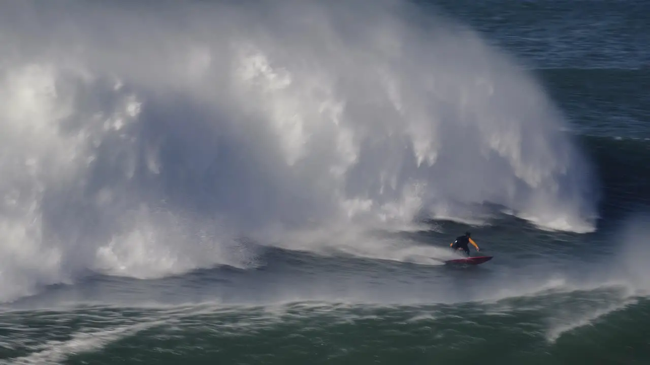 Jet ski driver riding big wave surfer surfing rough ocean closeup view real speed Nazare Portugal