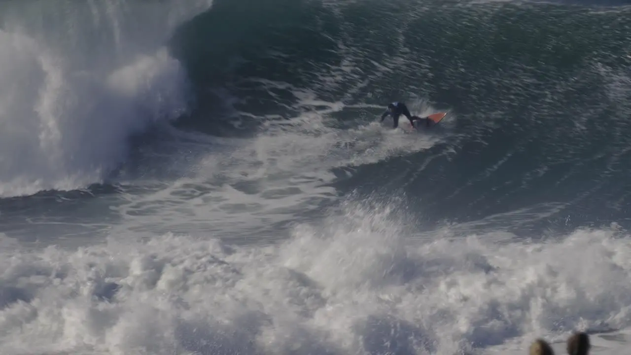 Surfer riding huge ocean wave in Nazare Portugal surfing is dangerous extreme sport