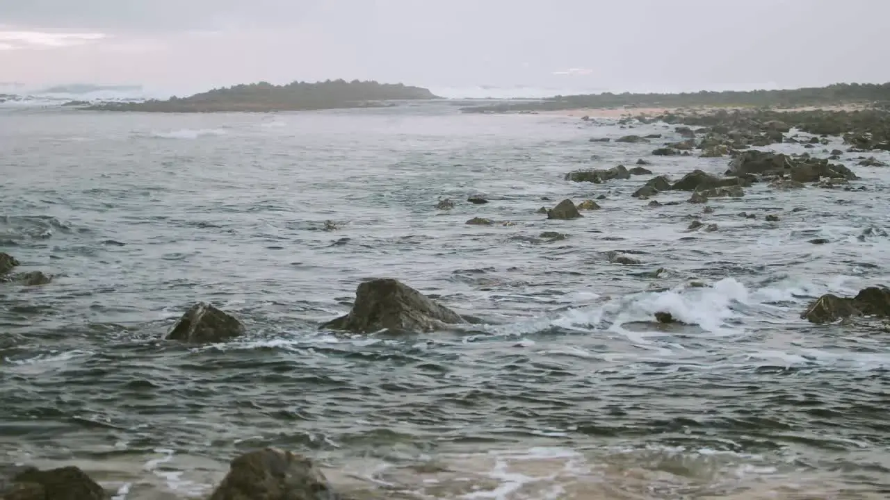 Light waves lapping along the rocky seaside shoreline