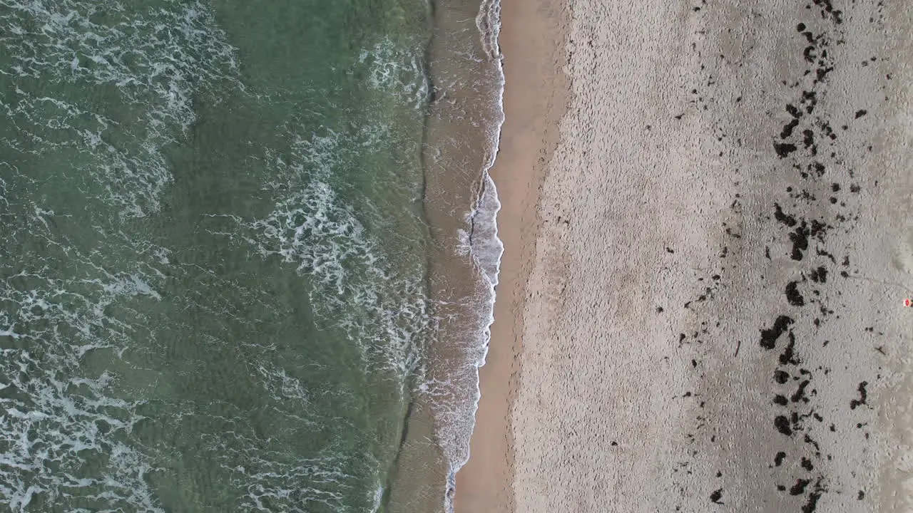 Top Down Aerial View of Atlantic Ocean Waves Breaking on Sandy Beach on Irish Coastline Barleycove County Cork Ireland