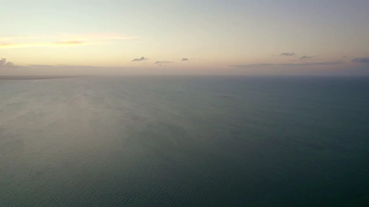 Aerial shot of a vibrant sunset setting over the ocean