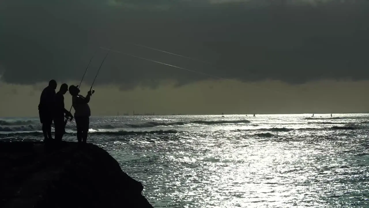 Fishermen cast at sunset at Ala Moana Beach Park in Honolulu Hawaii