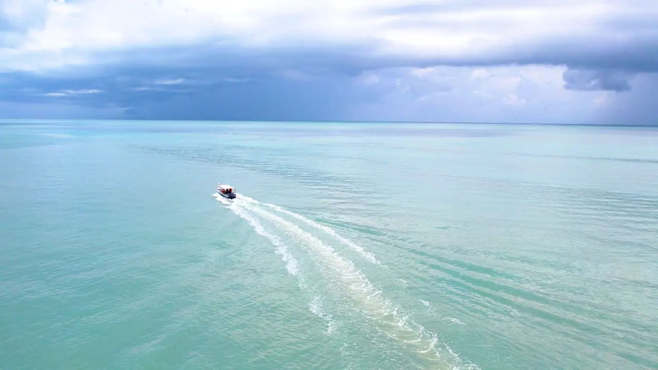 Aerial tracking shot tracking of a speedboat travelling through the tropical ocean