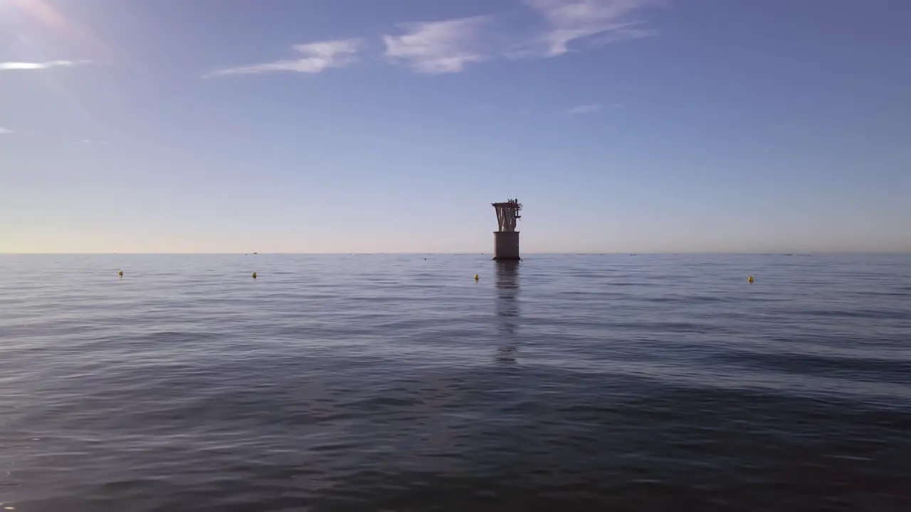 View of sea with an old overhead cable tower in the horizon