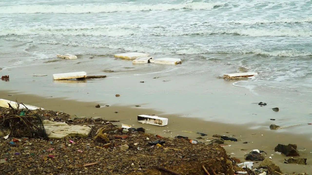 Industrial white story foam washed out to sandy coastline of Vietnam