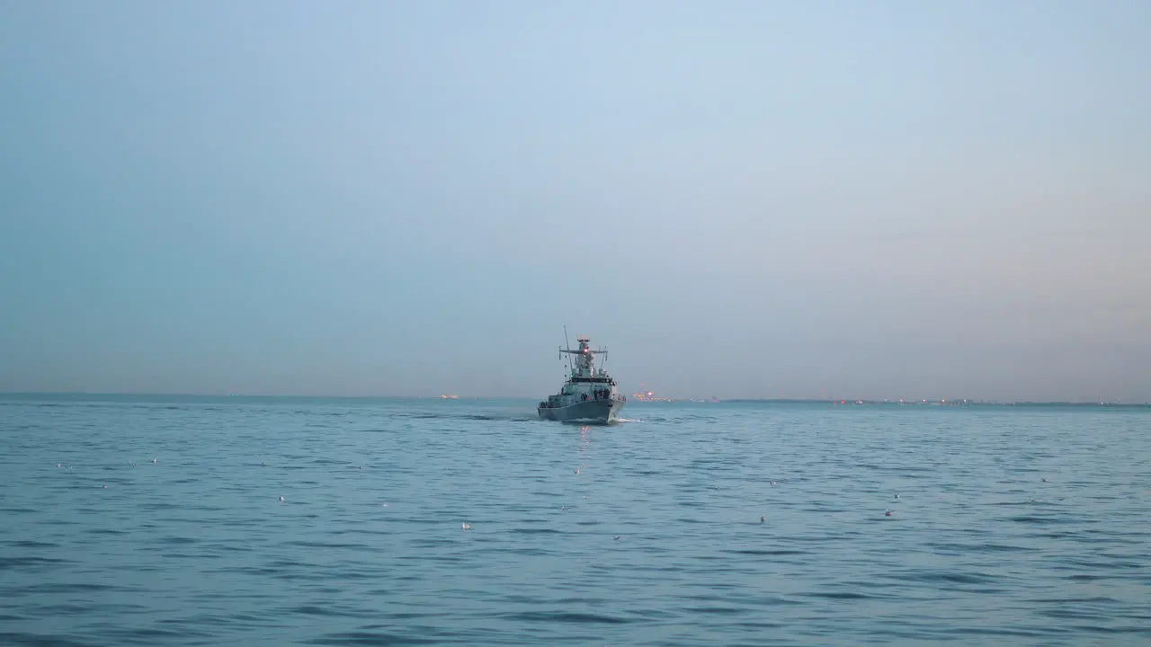 Military ship sailing on the sea at the sunset