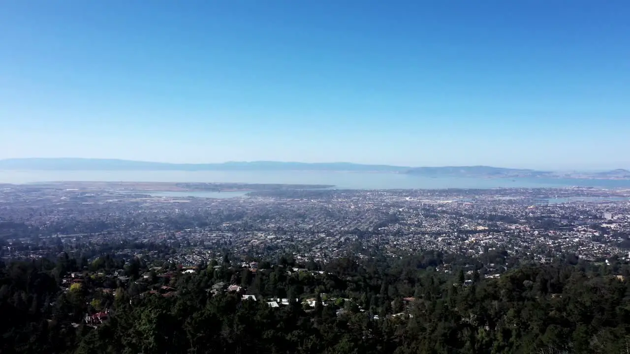 Pan to the right over a massive city in the bay on a sunny day