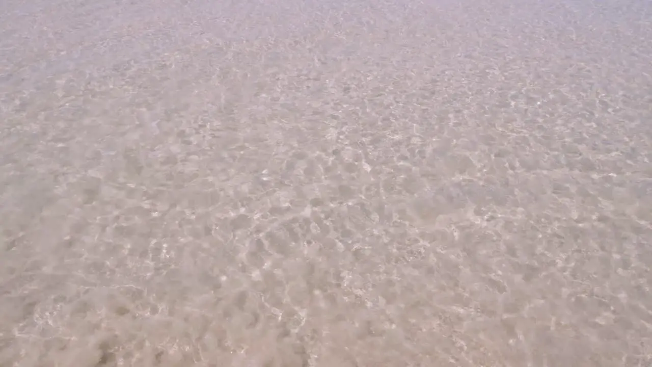 surface texture of the wave from calm sea on the white sand beach in summer sunshine time