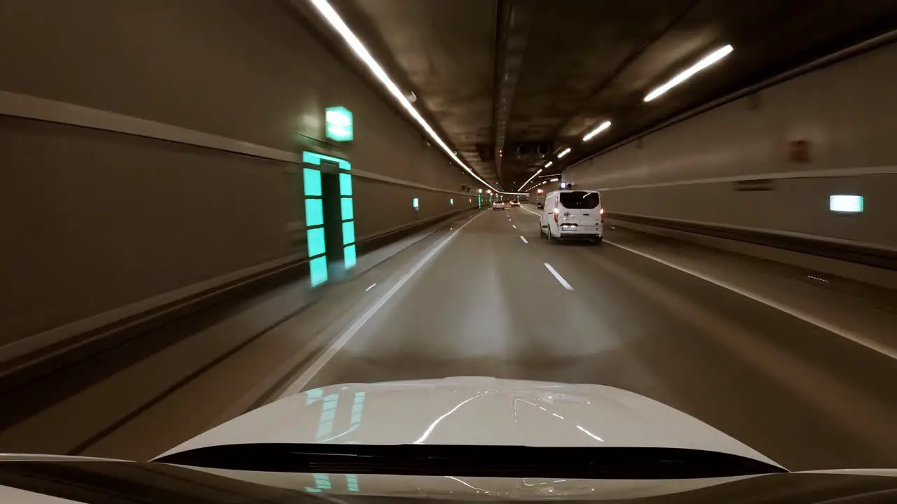 Wide angle view of a white car driving at night through a city