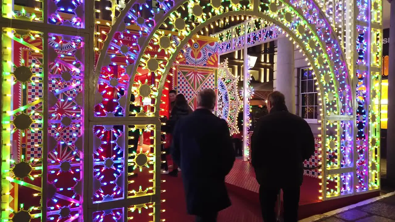 Walking around Covent Garden Christmas light show in London in December 2022 and showing how busy the location is with tourists in the evening during this festive period