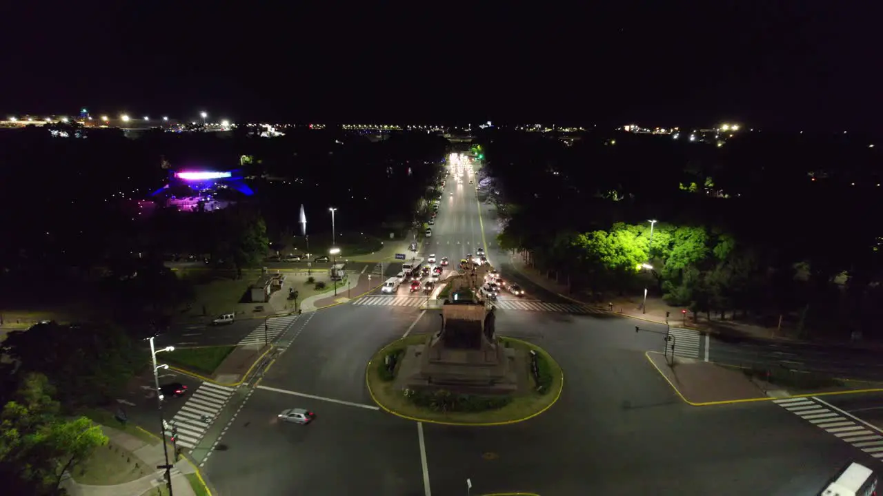 Dolly in aerial view of the street at night with low traffic and the Urquiza Monument and Planetarium unlit Buenos Aires Argentina