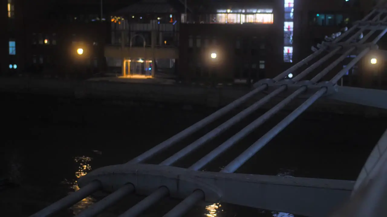 Close up shot of side details of Millennium bridge with the view of Thames river below in London England UK at night time