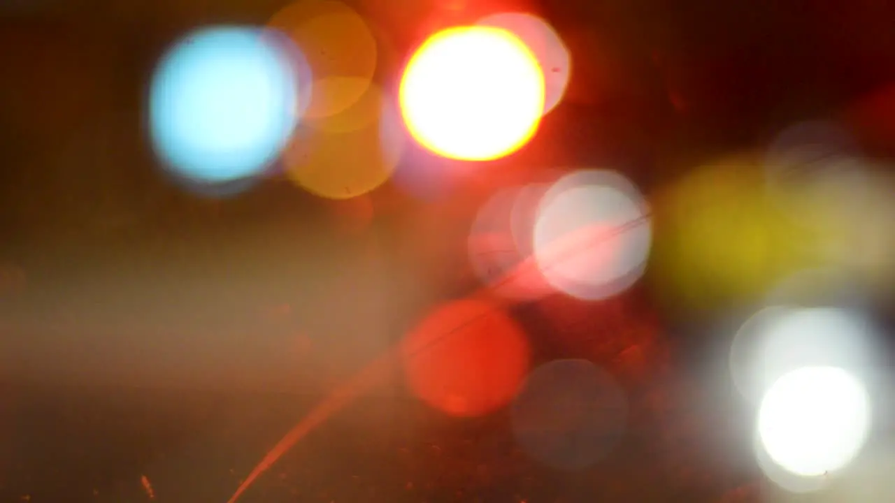 A blurred shot of car indicators traffic lights and headlights taken from inside a car