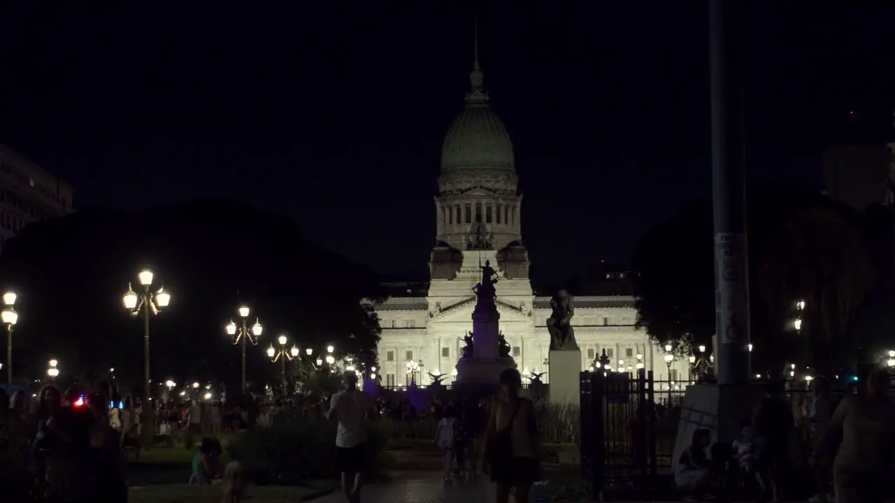 Establishing shot of National Congress public park at night with people walking