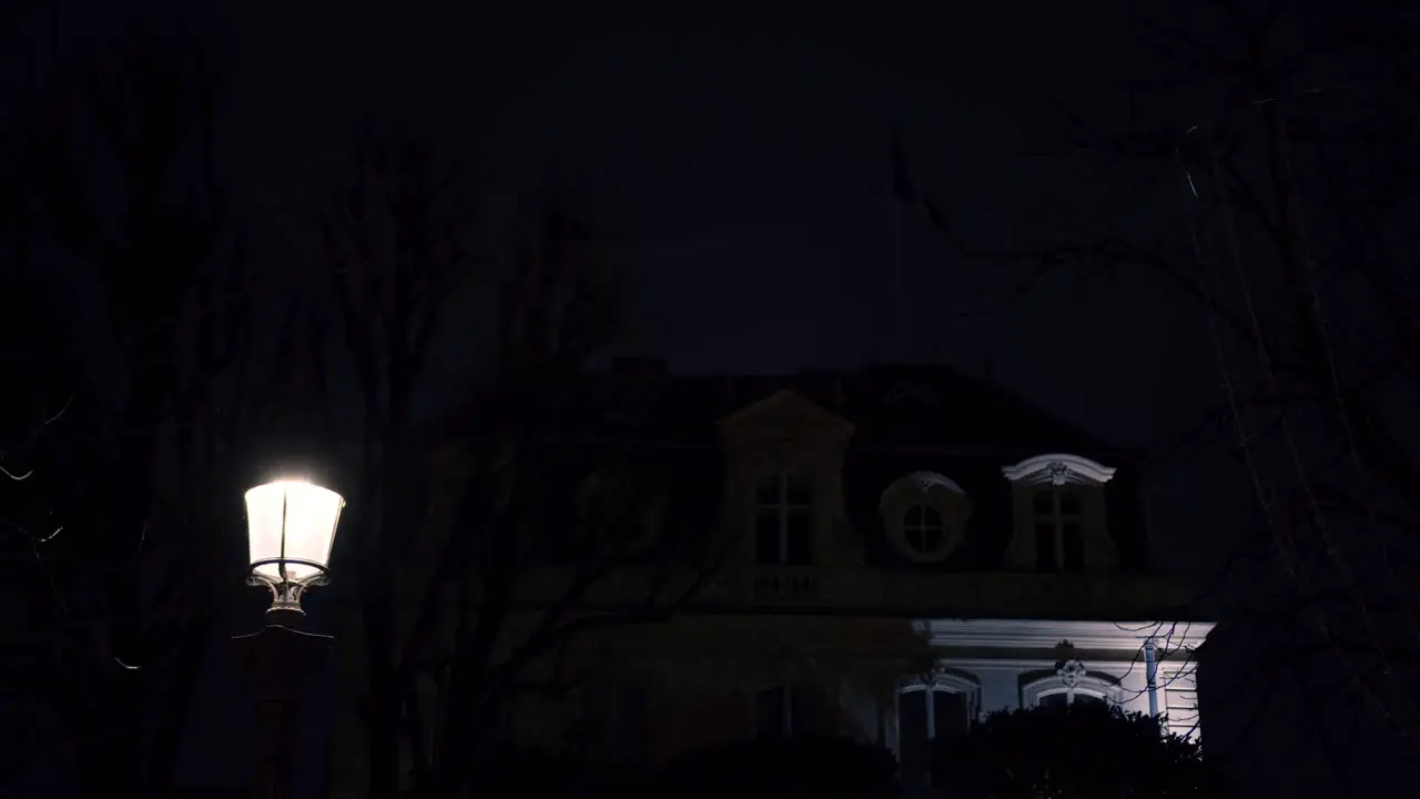 Low angle shot old well maintained bungalow with street lights in the foreground at night time