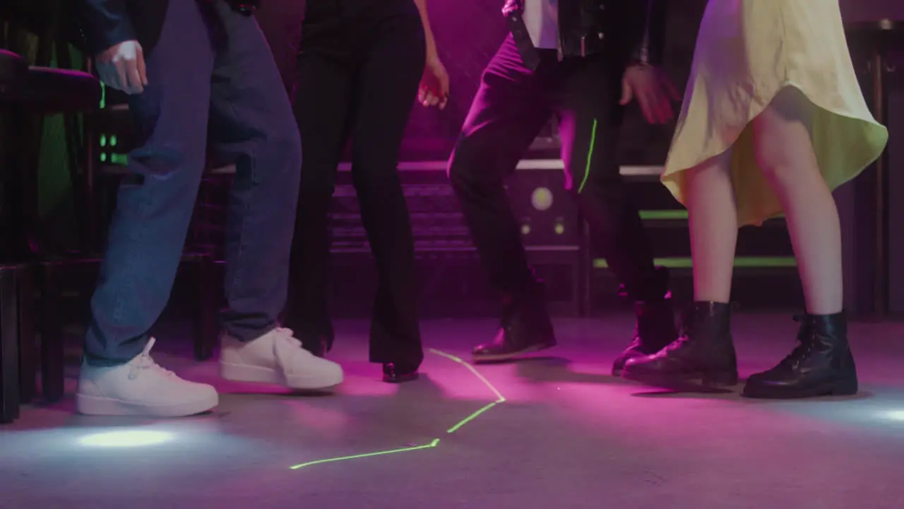 Close Up Of Legs Of Four Unrecognizable People Dancing At Disco Club