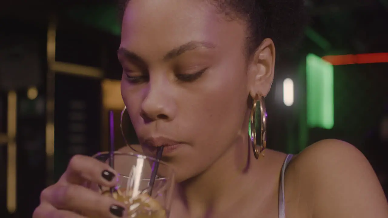 Close Up Of A Beautiful Girl Drinking Cocktail While Sitting At Bar Counter