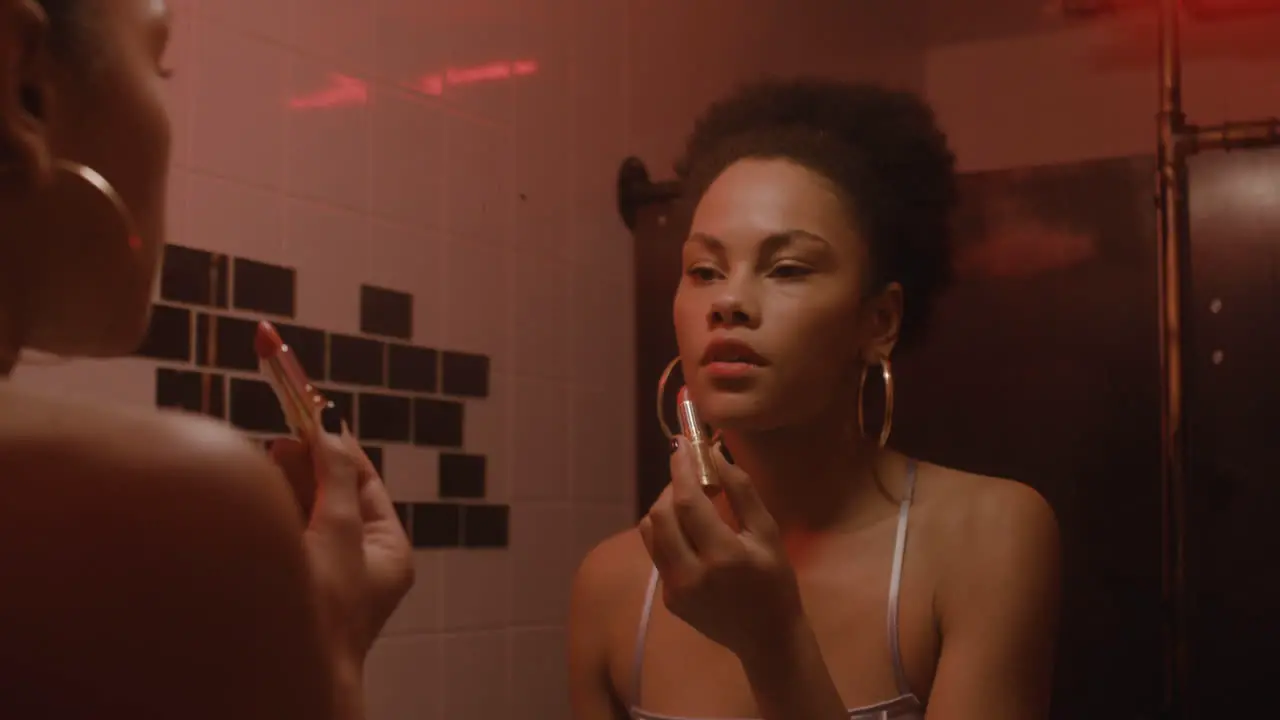 Beautiful Girl Putting Lipstick On While Looking At Mirror In A Bar Bathroom 1