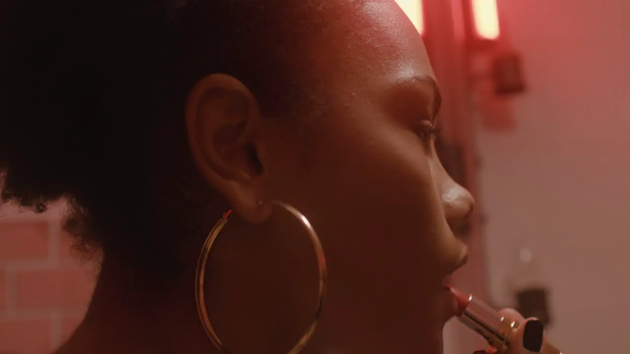 Close Up Of A Beautiful Girl Putting Lipstick On While Looking At Mirror In A Bar Bathroom