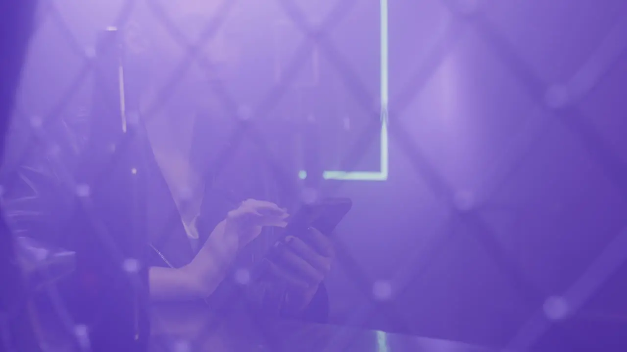 Close Up Of A Beautiful Girl Using Mobile Phone While Sitting At Disco Club