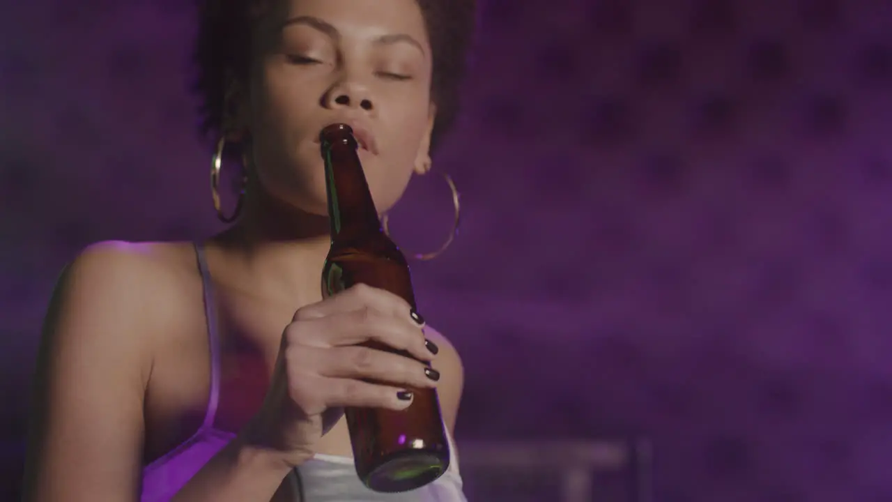 Close Up Of An Attractive Girl Drinking Beer And Dancing At Disco