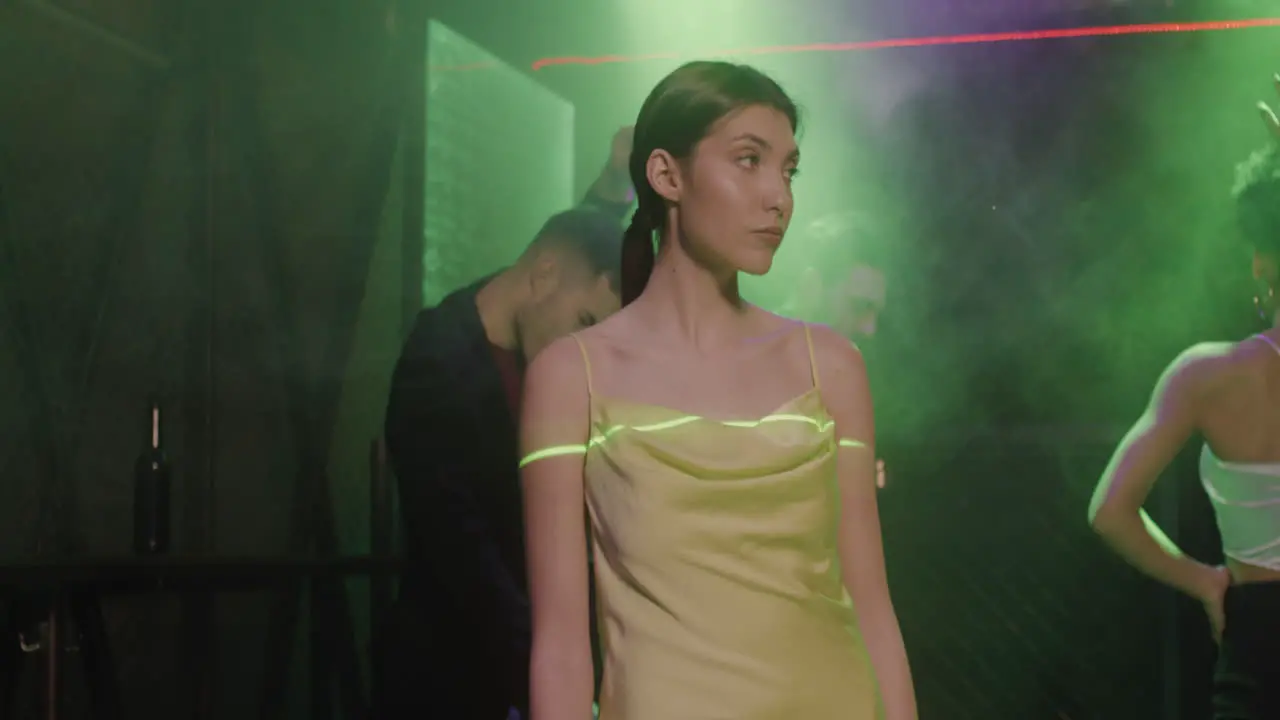 Portrait Of Beautiful Girl Looking Confident At Camera At Disco While Her Friends Dancing Behind Her 1