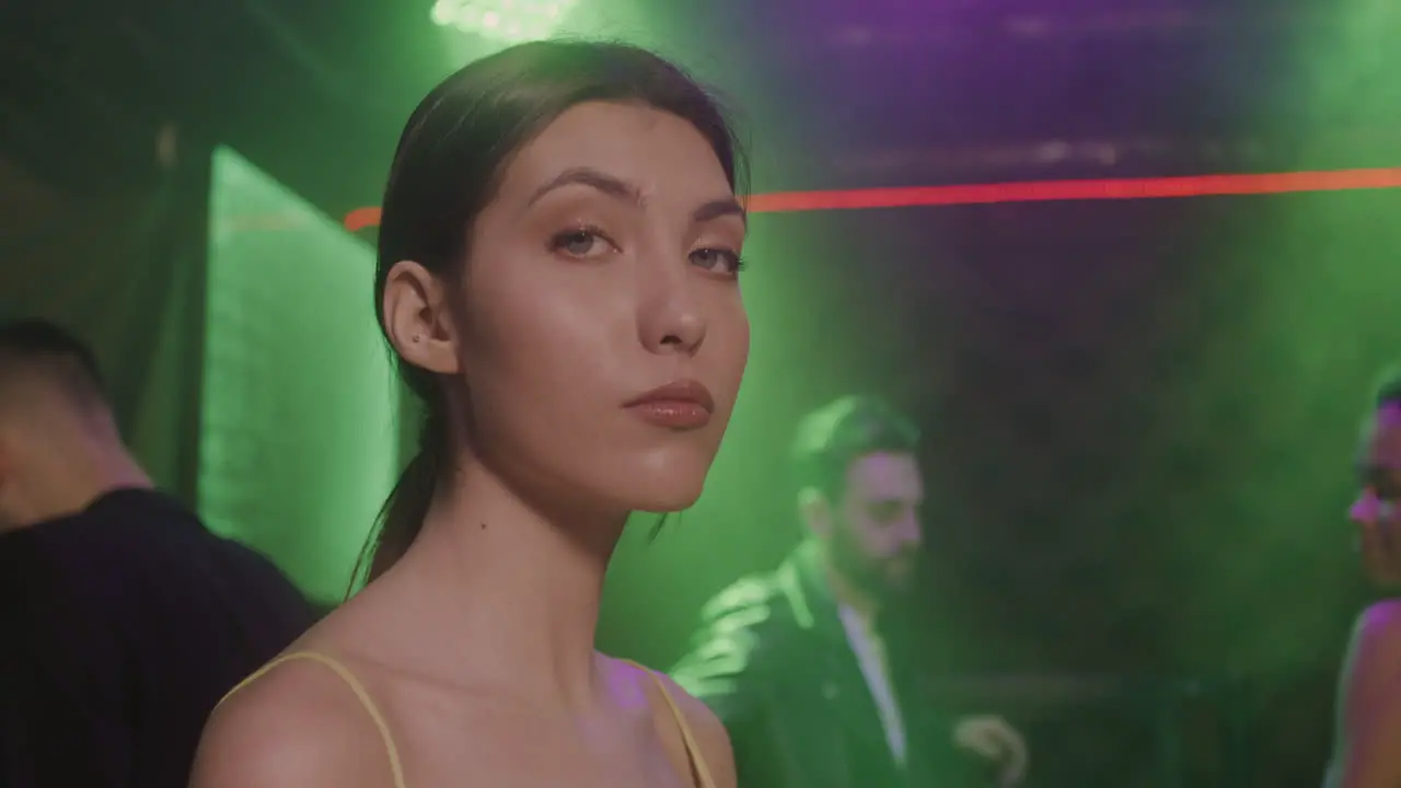 Portrait Of Beautiful Girl Looking Confident At Camera At Disco While Her Friends Dancing Behind Her 1 1