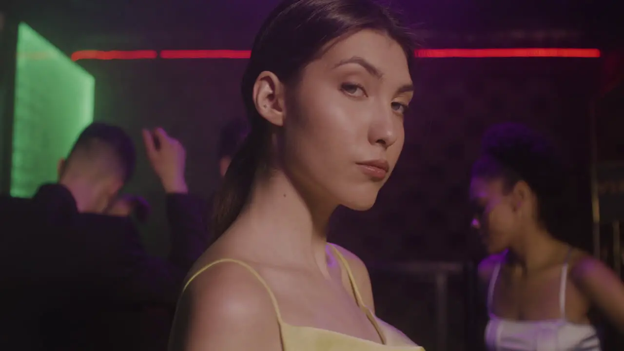 Portrait Of Beautiful Girl Looking Confident At Camera At Disco While Her Friends Dancing Behind Her 2 1