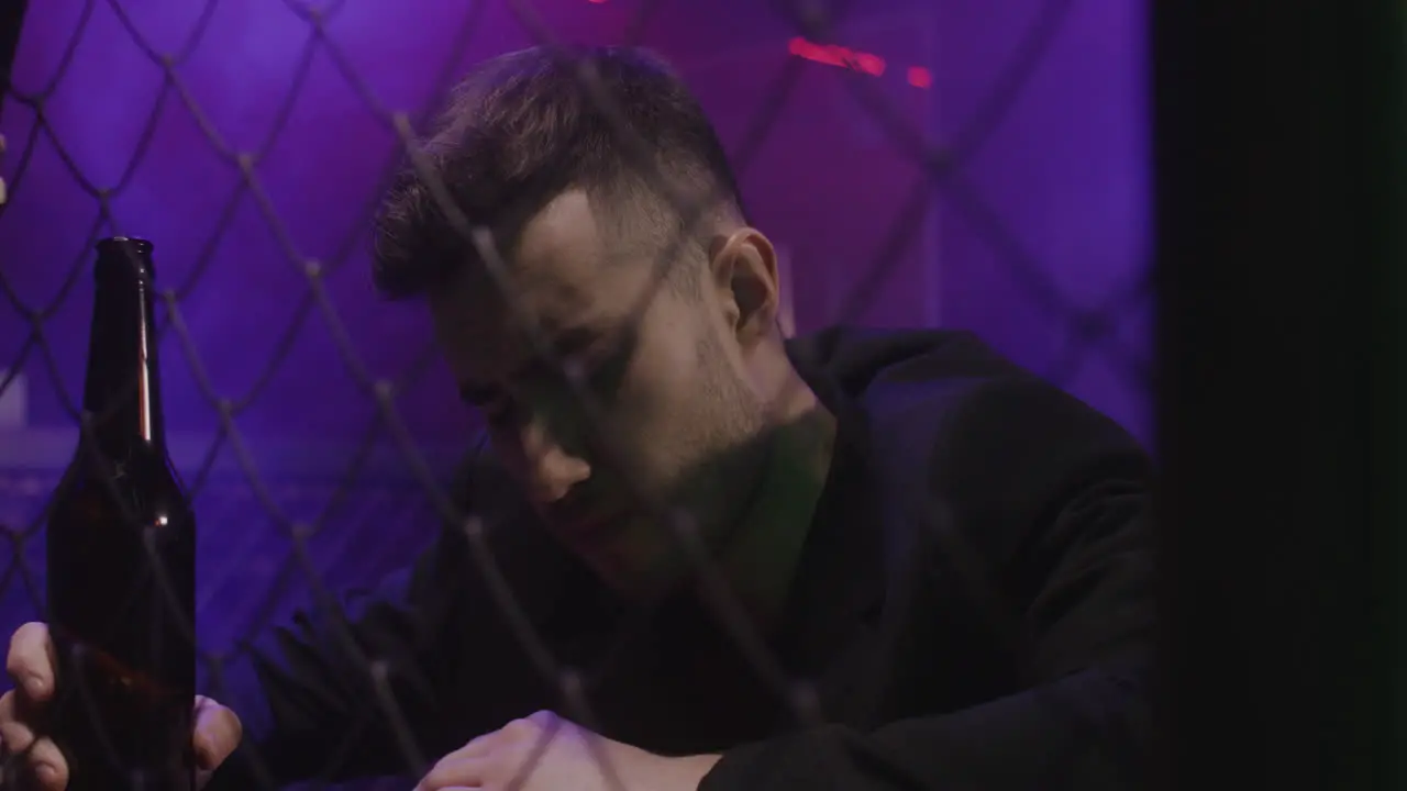 Drunk Man Drinking Beer While Sitting Alone At Disco Club