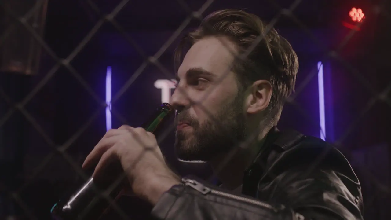 Handsome Bearded Man Drinking Beer And Talking With Someone At Disco