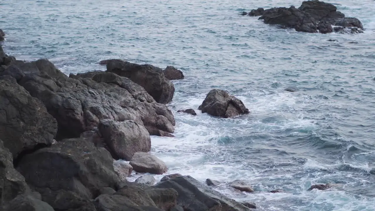 Relaxing Blue Waves Crashing into Large Rocks on Coast