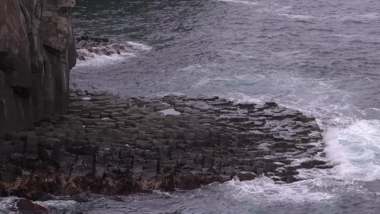 Ocean Waves Breaking On Beautiful Volcanic Rocks Against Cliffs wide shot