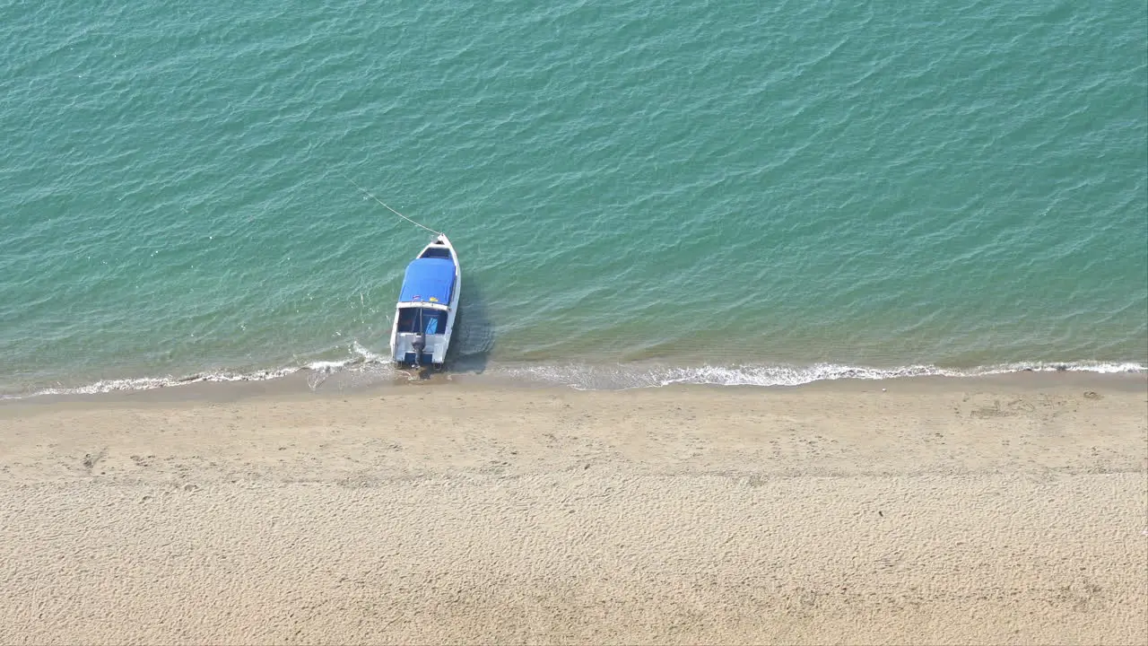 Small Boat Anchored in Sea by Sandy Tropical Beach High Angle View