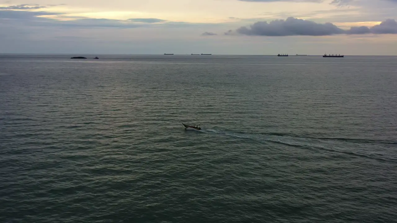 Aerial drone flyover shot capturing small traditional small fishing boat sailing on the sea