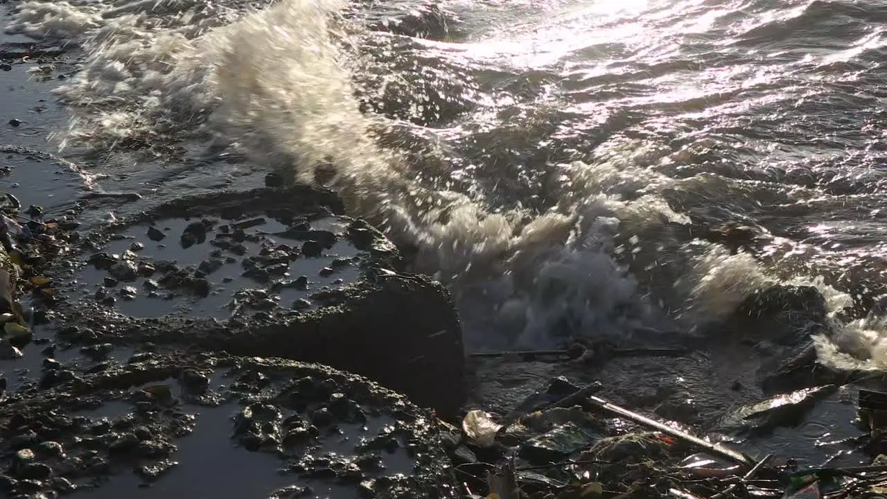 close up slow motion ocean waves crashing against the beach barrier