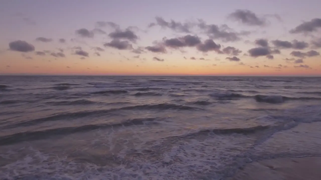 Sea Waves Rinse Seaside Beach At Sunset