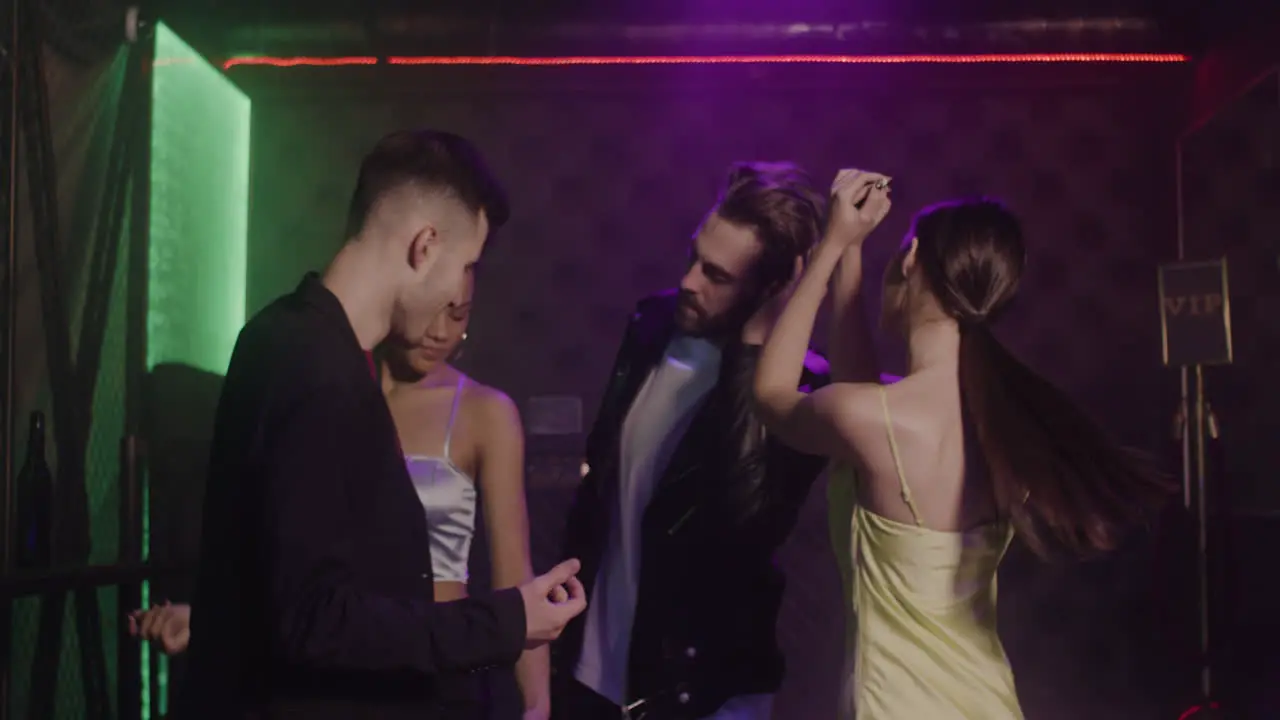 Group Of Four Young Friends Dancing At Disco 1