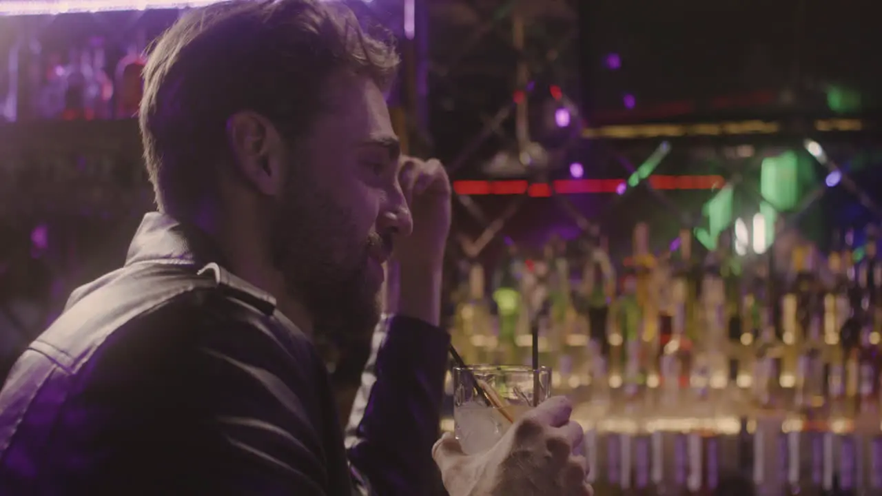 Multiethnic Couple Drinking And Talking Together While Sitting At Bar Counter