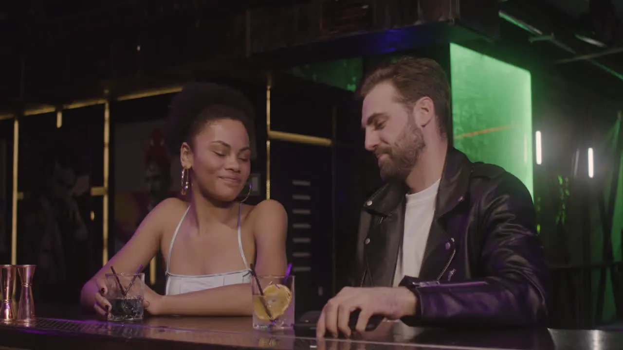 Multiethnic Couple Talking Together And Taking A Selfie Photo While Sitting At Bar Counter