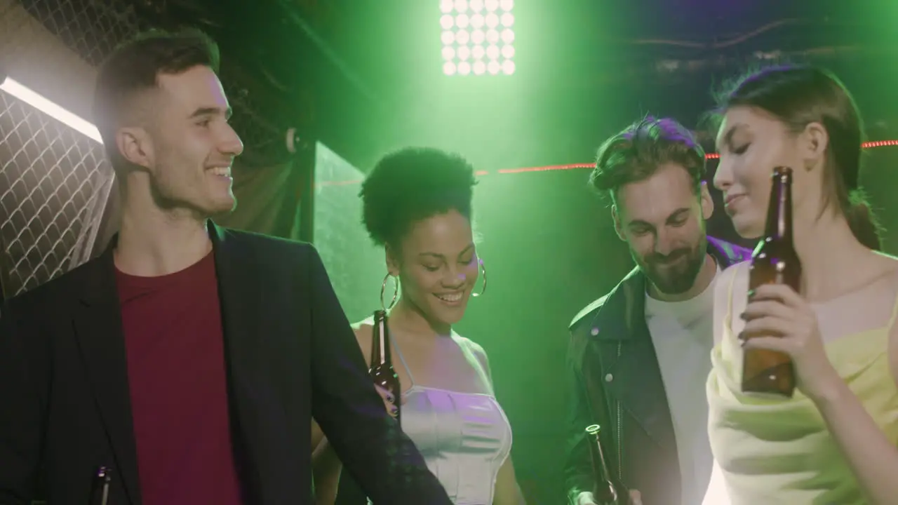 Group Of Four Young Friends Holding Beer And Dancing At Disco 2