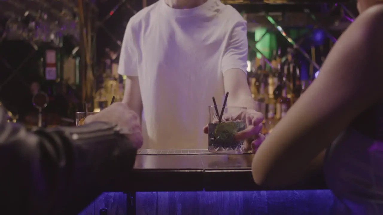 Close Up Of Waiter Serving Drinks To Unrecognizable Couple Sitting At Bar Counter