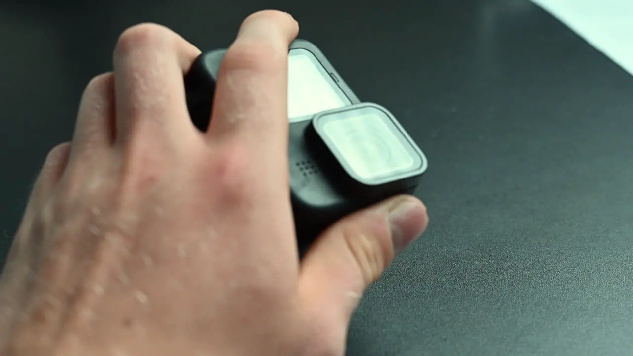 A filmmaker holds an action cam between his fingers with a rectangular lens-1