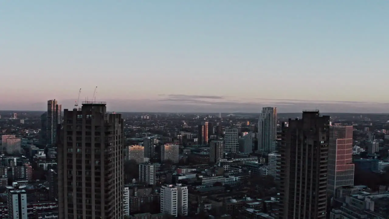 Rising drone shot of Barbican towers framing north London early morning