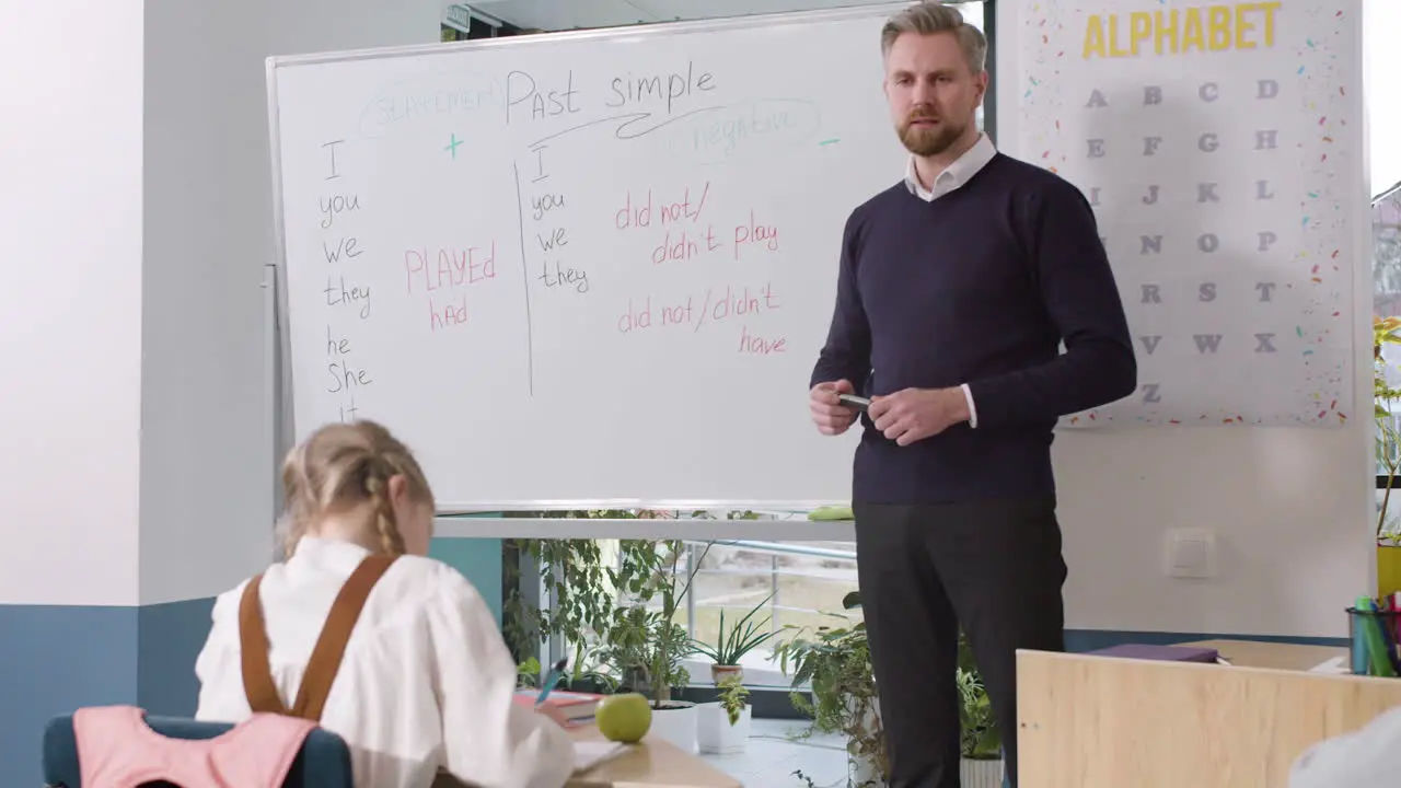 Englischer Männlicher Lehrer Der Past Simple Erklärt Und Dann Einen Schüler An Die Tafel Ruft 2