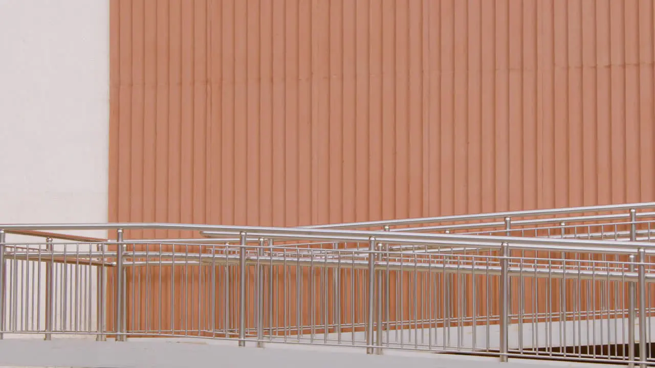 Young American Man In Formal Clothes Going To Work On Bicycle And Passing In Front Of A Prefab Metal Building 1