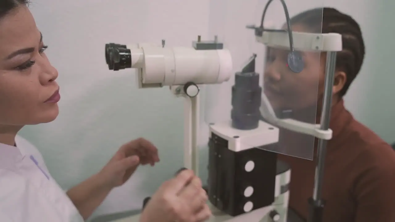 Female Eye Specialist Does Vision Test On Young Girl With A Vision Measuring Machine