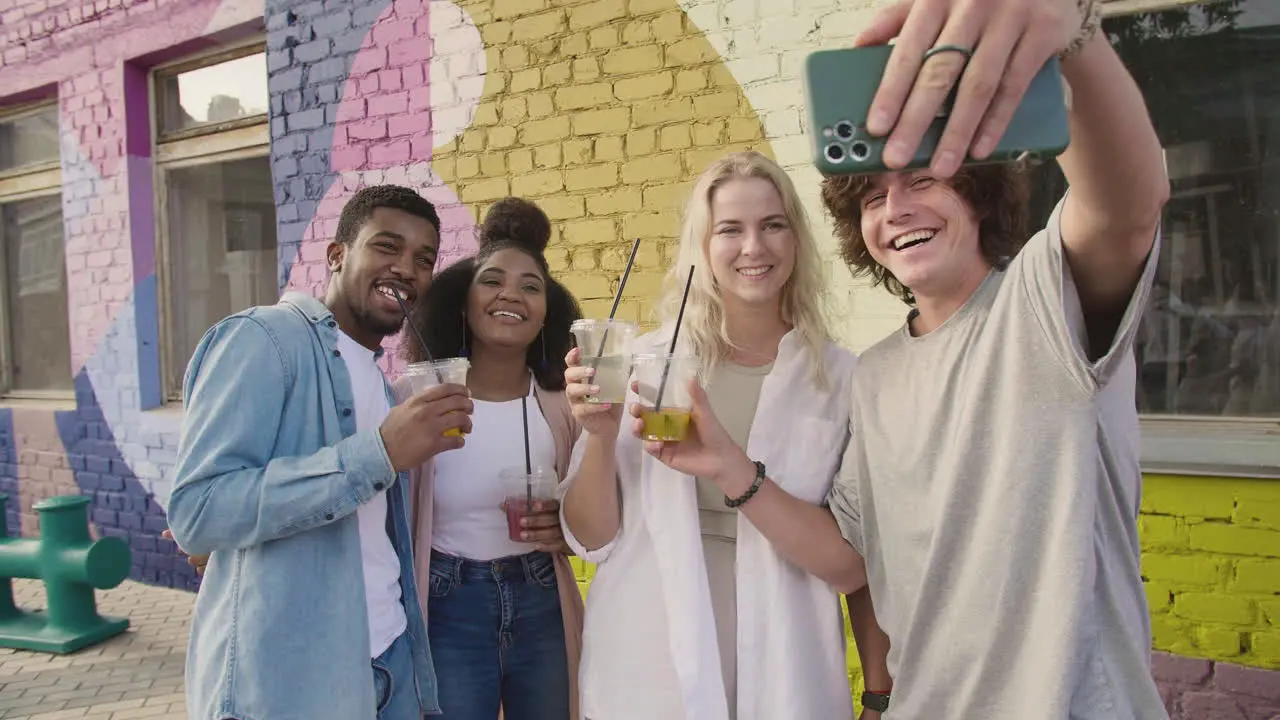 Group Of Young Friends Taking Selfies Together And Having Fun Outdoors While Holding Their Fresh Drinks In Plastic Cups 1