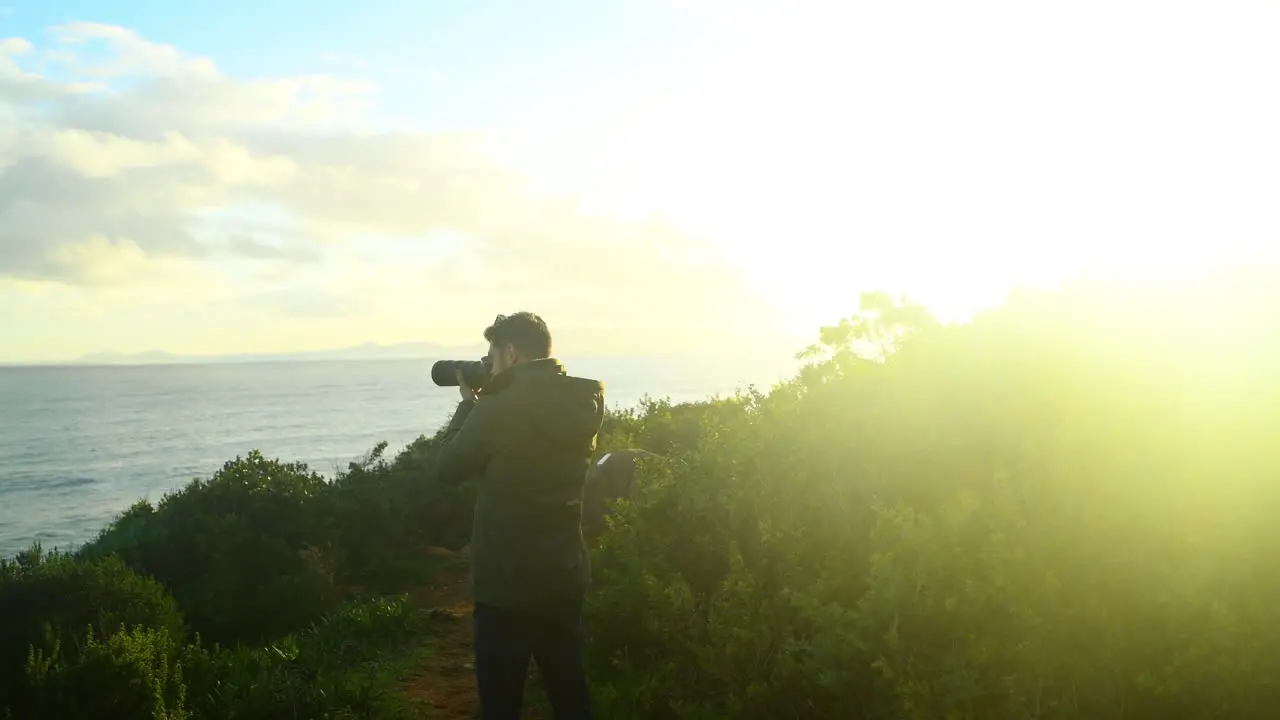 a young man taking a photo using a dslr camera